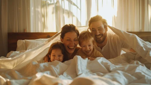Mom, dad and the kids playing in bed
